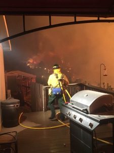 Image of a firefighter defending a home during the 2018 Lake Christine Fire