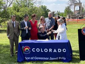 Image of a Colorado Bill signing featuring Governor Pollis and others