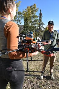 Photo of conference sponsor with an attendee, and a drone, at the 2024 Colorado Wildland Fire Conference